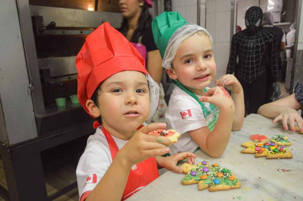 Crianças felizes com suas produções na estação doce do evento padeirinhos